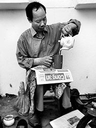This is Nguyen Van Bac, a shoe polisher from Hanoi. When I saw him cleaning some shoes I stopped and asked for taking a picture. It didn't take long until he offered me a tea.