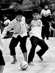 Two boys are playing football in front of the St Joseph church in Hanoi.