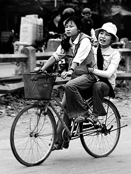 Two people riding on a bycicle is till a common scene in Vietnam.<br><br>Often two pupils share one bike.