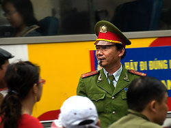 A policemen who tries to bring the traffic under control. A giant traffic jam was build up after a fight was going on between a bus driver and a motor scooter driver on a crossing in the old quarter in Hanoi
